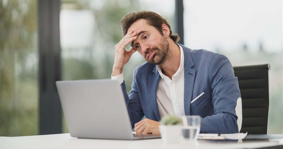 Tired businessman resting his head on his hand at a laptop in the afternoon