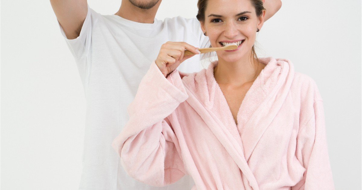 Couple brushing their teeth together in the bathroom in the morning