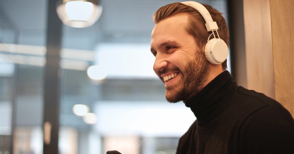 Smiling man wearing white headphones during a sound therapy session