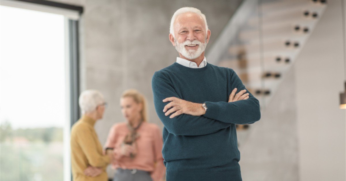 Confident senior man standing with his arms crossed at a clinic